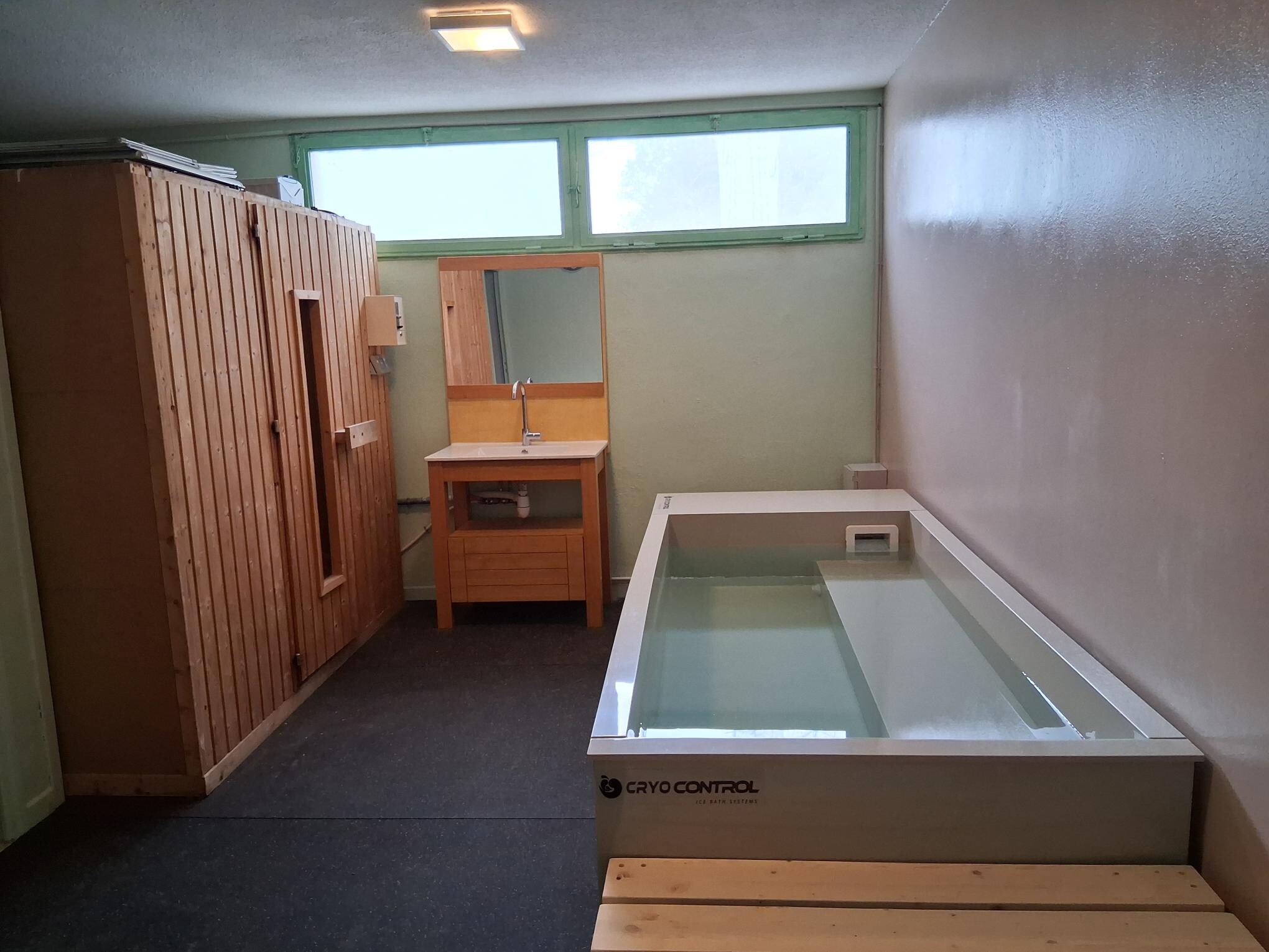 Photo de lespace récupération où il y a le bain froid au 1er plan et au second plan le sauna